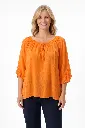 Femme souriante en tunique orange.webp